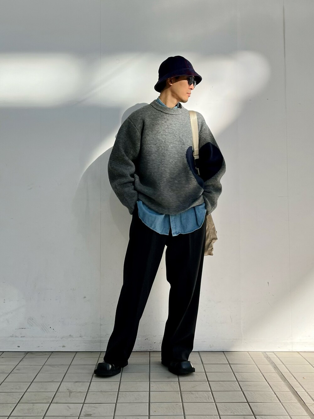 グレー系のニット/セーター、ブルー系のシャツ/ブラウス、ブラック系のその他パンツを着用したメンズの冬コーディネートの2枚目の写真