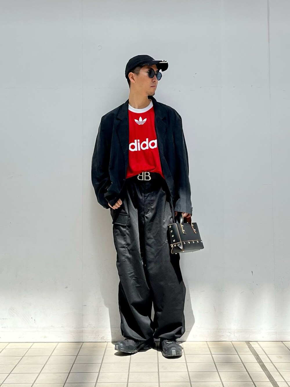 ブラック系のテーラードジャケット、レッド系のTシャツ/カットソー、ブラック系のカーゴパンツを着用したメンズの春コーディネートの2枚目の写真