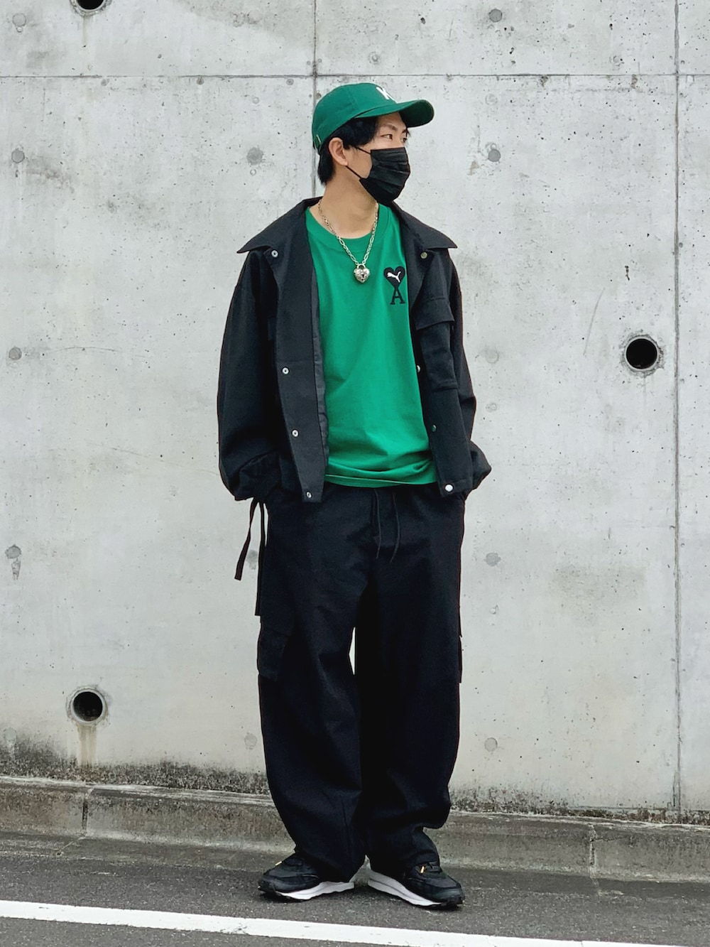 ブラック系のブルゾン、グリーン系のTシャツ/カットソー、ブラック系のカーゴパンツを着用したメンズの春コーディネートの2枚目の写真