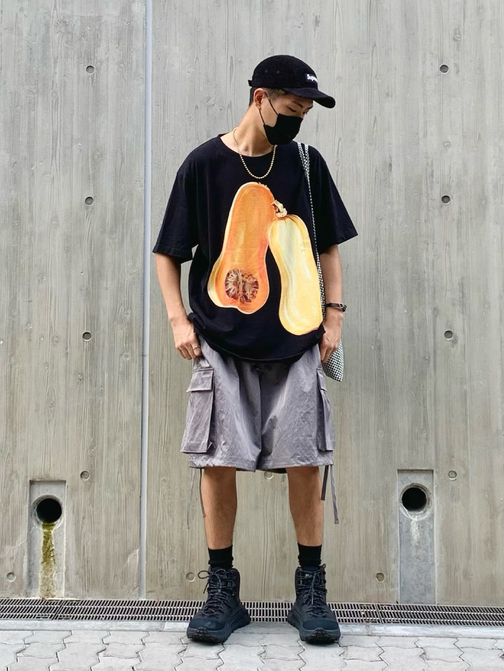 ブラック系のTシャツ/カットソー、グレー系のカーゴパンツ、ブラック系のスニーカーを着用したメンズの夏コーディネートの2枚目の写真