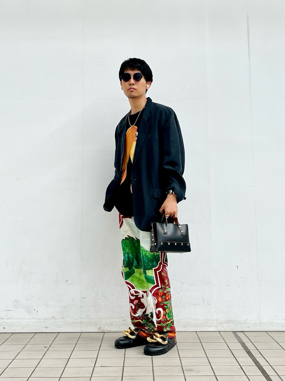 ブラック系のテーラードジャケット、ブラック系のTシャツ/カットソー、ブラウン系のデニムパンツを着用したメンズの夏コーディネートの2枚目の写真