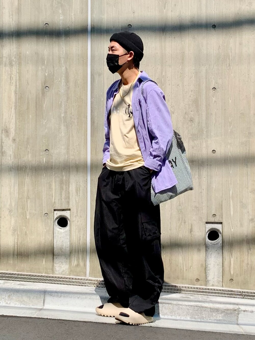 ベージュ系のTシャツ/カットソー、ブラック系のカーゴパンツ、ベージュ系のサンダルを着用したメンズの春コーディネートの2枚目の写真