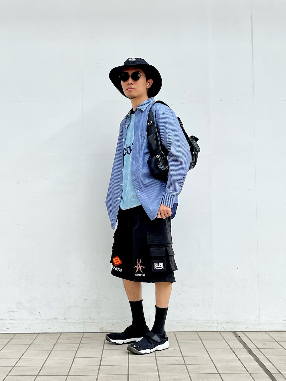 ブルー系のシャツ/ブラウス、ブルー系のTシャツ/カットソー、ブラック系のスニーカーを着用したメンズの春コーディネートの2枚目の写真