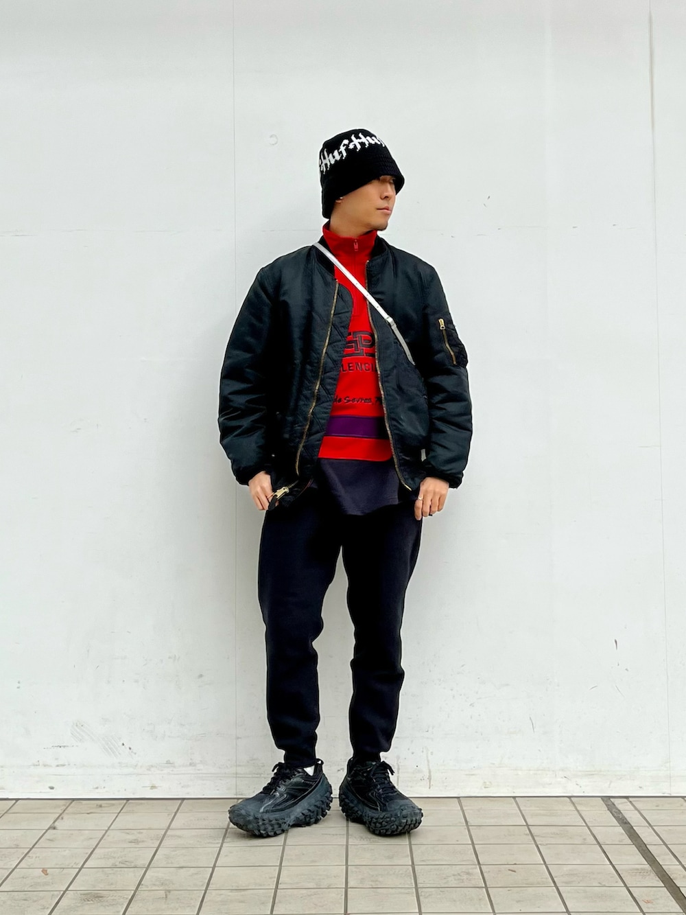 ブラック系のMA-1、ブラック系のスウェットパンツ、ブラック系のスニーカーを着用したメンズの冬コーディネートの2枚目の写真