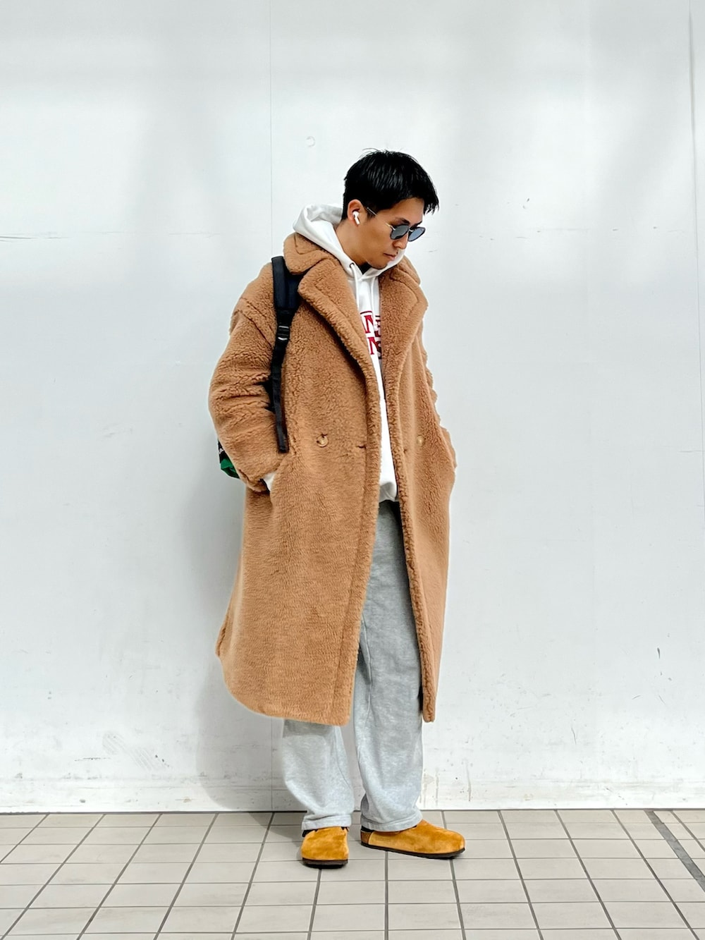 ホワイト系のパーカー、グレー系のカーゴパンツ、ブラウン系のサンダルを着用したメンズの冬コーディネートの2枚目の写真