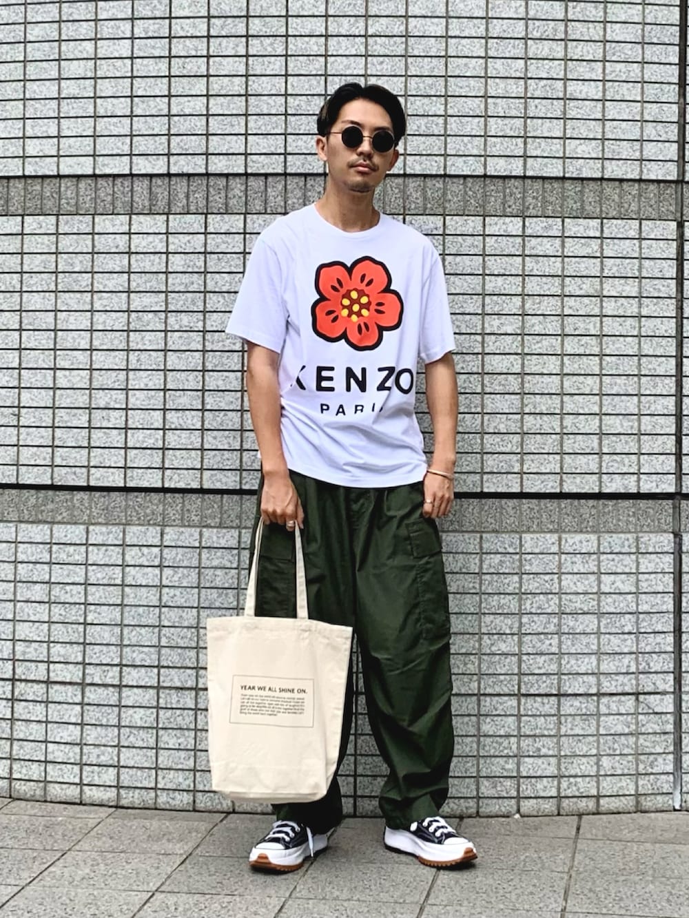 ホワイト系のTシャツ/カットソー、グリーン系のカーゴパンツ、ブラック系のスニーカーを着用したメンズの夏コーディネートの3枚目の写真