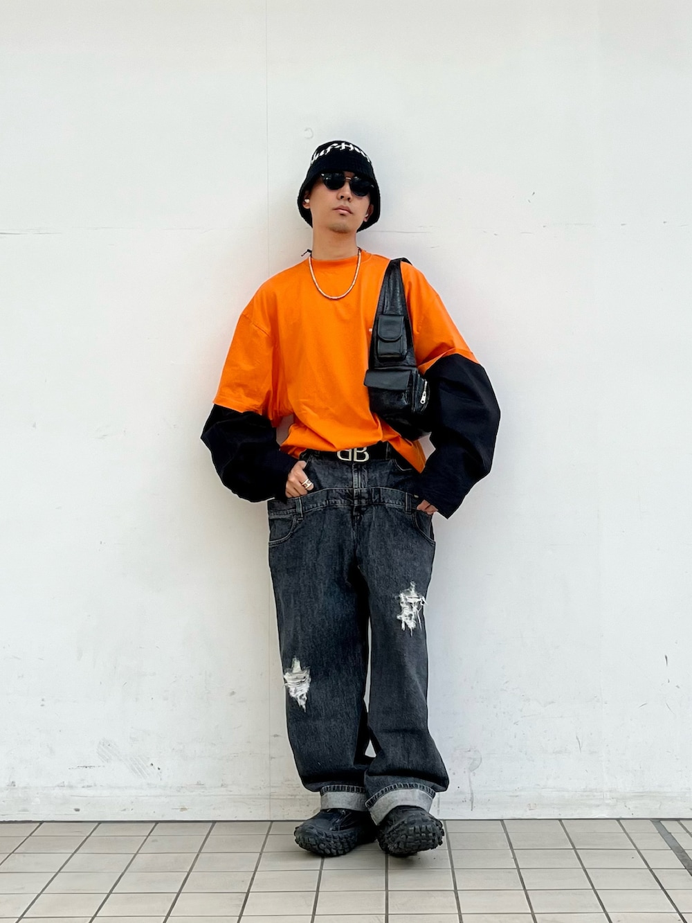 「おしゃれさんと繋がりたい、ロゴT、ロンT、オレンジ、レイヤードスタイル、レイヤード、デニム、デニムパンツ、ダブルウエスト、ストリート、オーバーサイズ、スリングバッグ、春服」｜「JW Andersonのアイテム（デニムパンツ、グレー系）」を使った、macky☺︎さん（メンズ・172cm）の春コーディネートの2枚目の写真