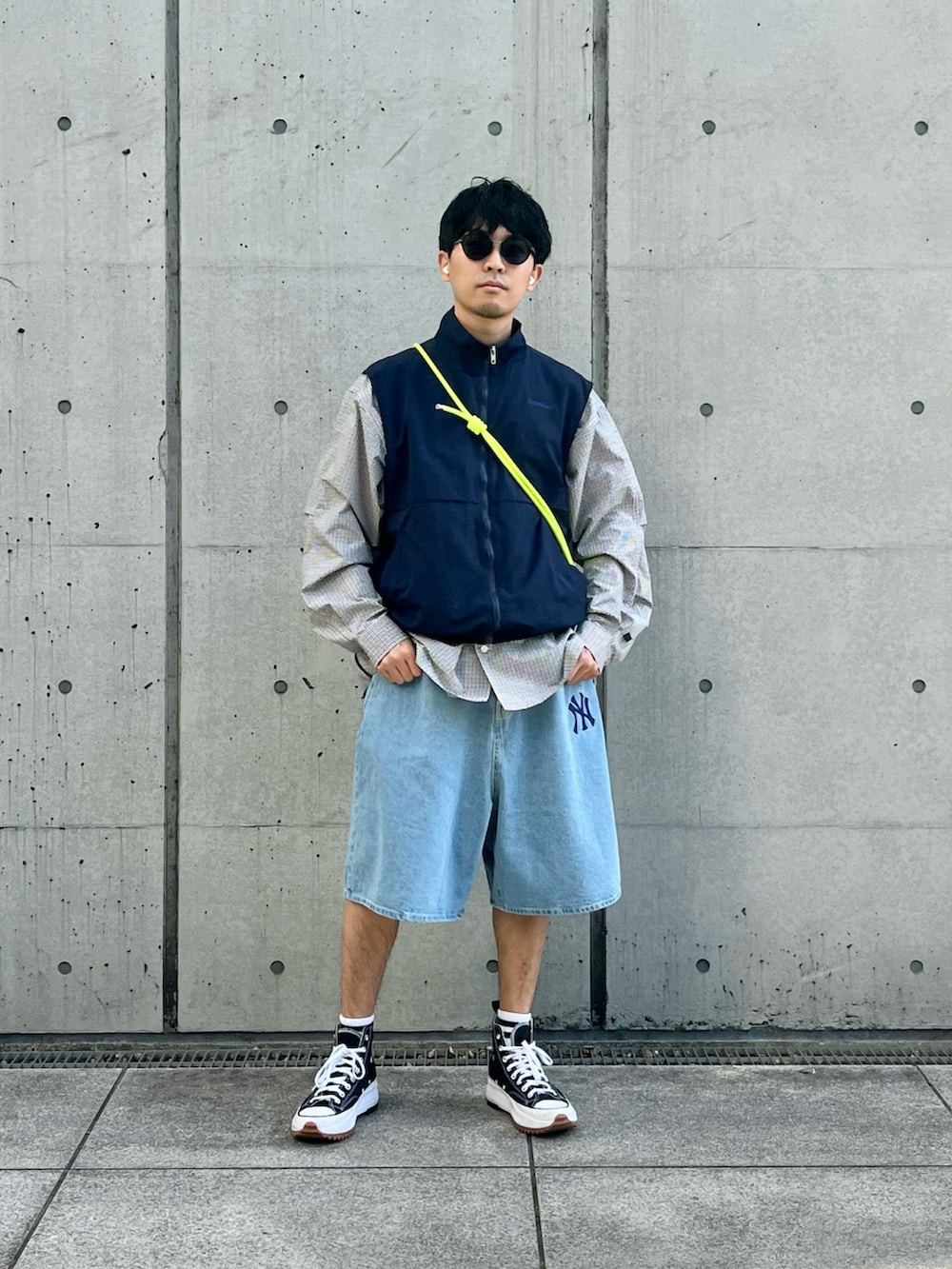 ブルー系のベスト、ブラウン系のシャツ/ブラウス、ブルー系のデニムパンツを着用したメンズの春コーディネートの2枚目の写真