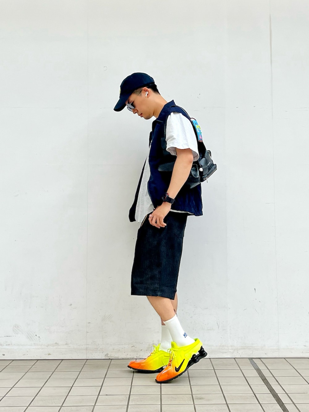 グレー系のTシャツ/カットソー、ブルー系のベスト、ブラック系のデニムパンツを着用したメンズの夏コーディネートの2枚目の写真