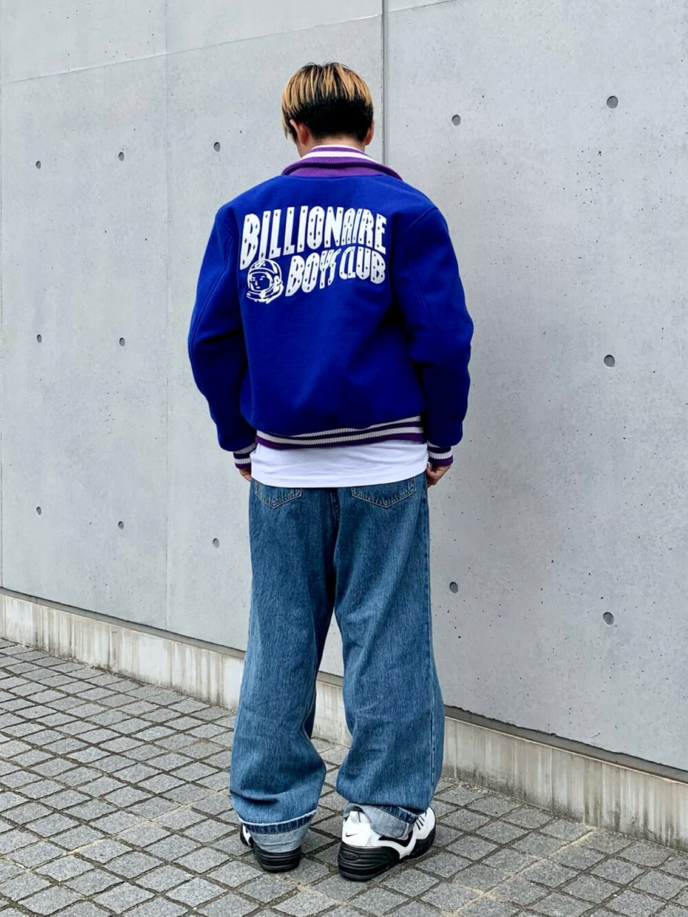 ブルー系のスタジャン、ホワイト系のTシャツ/カットソー、ブルー系のデニムパンツを着用したメンズの秋コーディネートの2枚目の写真