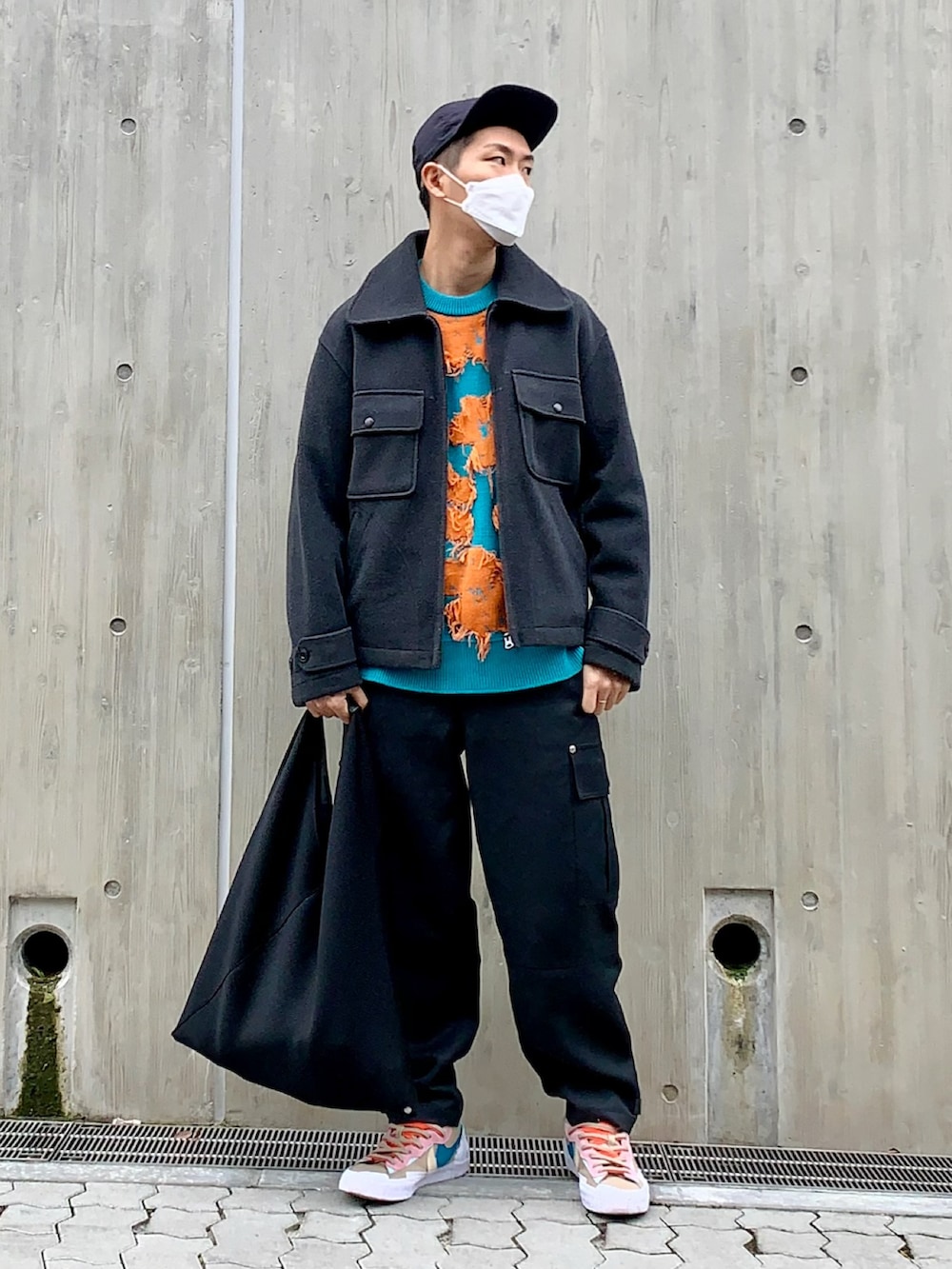 グレー系のジャケット/アウター、ブルー系のニット/セーター、ブラック系のカーゴパンツを着用したメンズの冬コーディネートの2枚目の写真