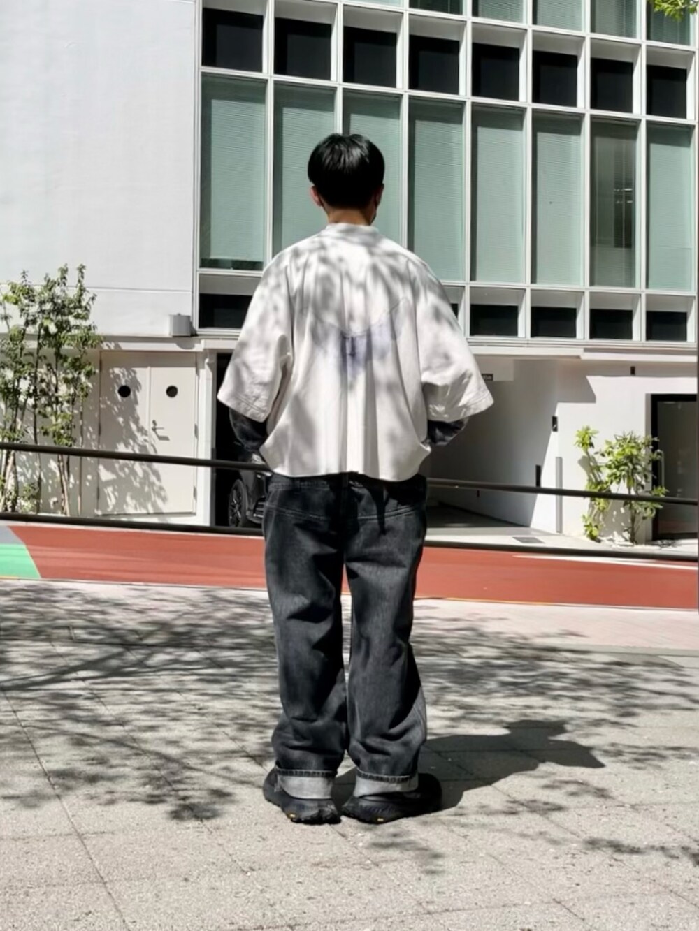 グレー系のTシャツ/カットソー、ブラック系のTシャツ/カットソー、グレー系のデニムパンツを着用したメンズの春コーディネートの2枚目の写真