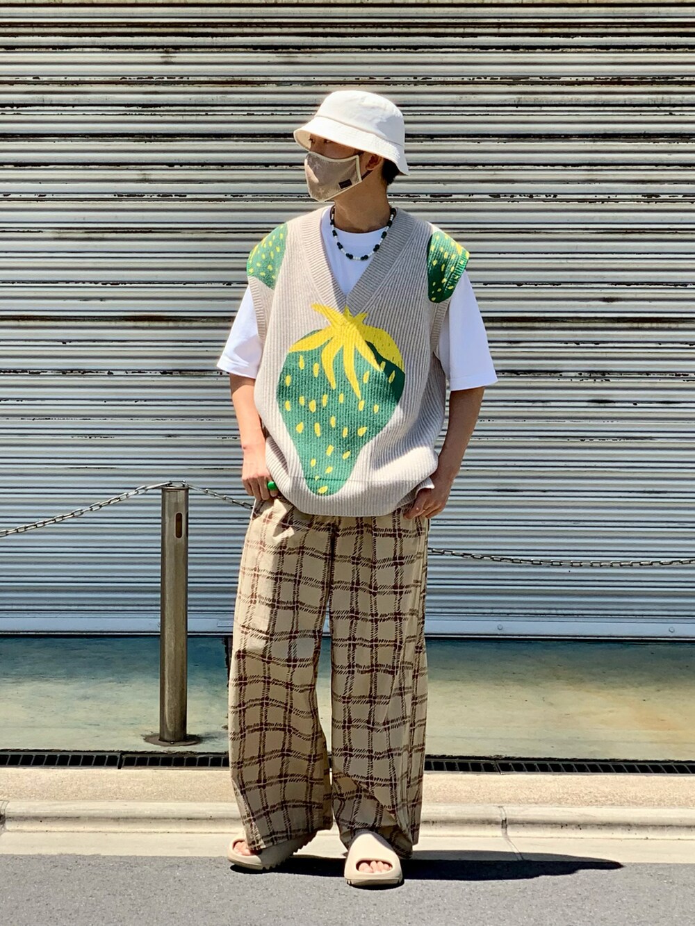 ベージュ系のベスト、ホワイト系のTシャツ/カットソー、ベージュ系のパンツを着用したメンズの春コーディネートの2枚目の写真