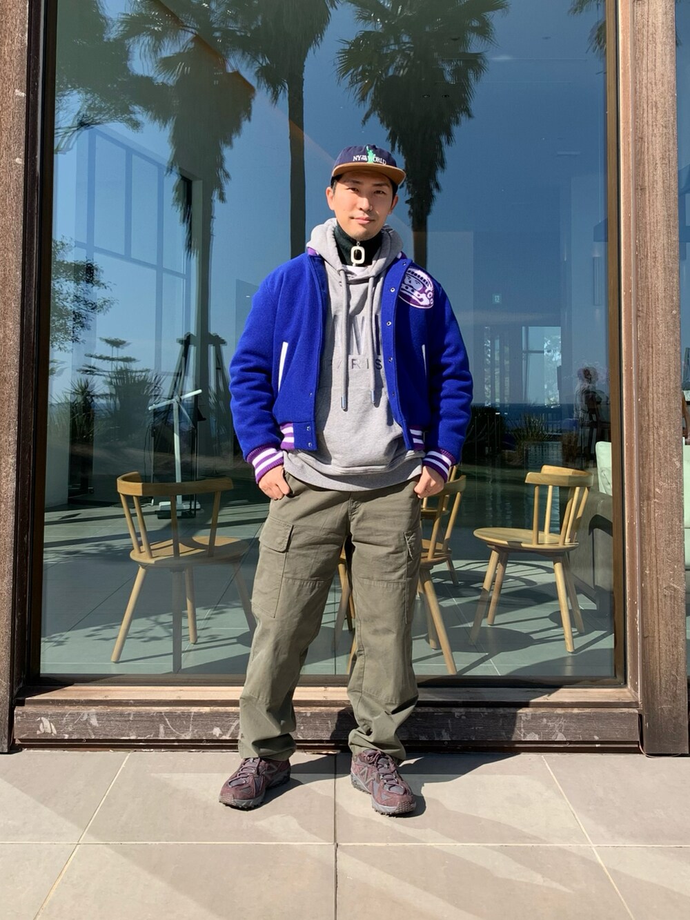 ブルー系のスタジャン、グレー系のパーカー、グリーン系のカーゴパンツを着用したメンズの冬コーディネートの2枚目の写真