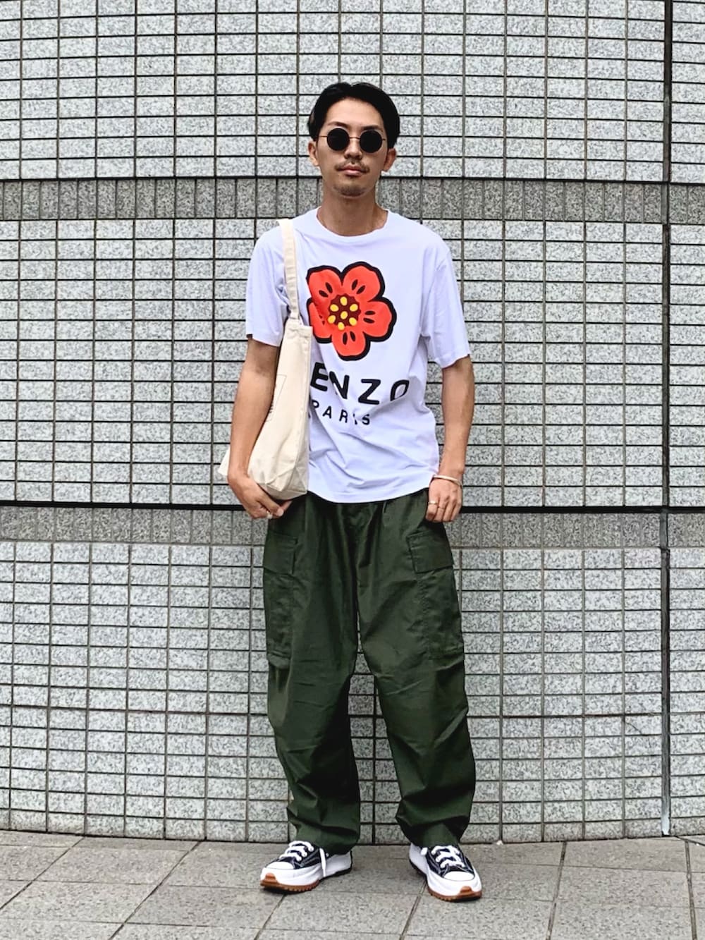 ホワイト系のTシャツ/カットソー、グリーン系のカーゴパンツ、ブラック系のスニーカーを着用したメンズの夏コーディネートの2枚目の写真