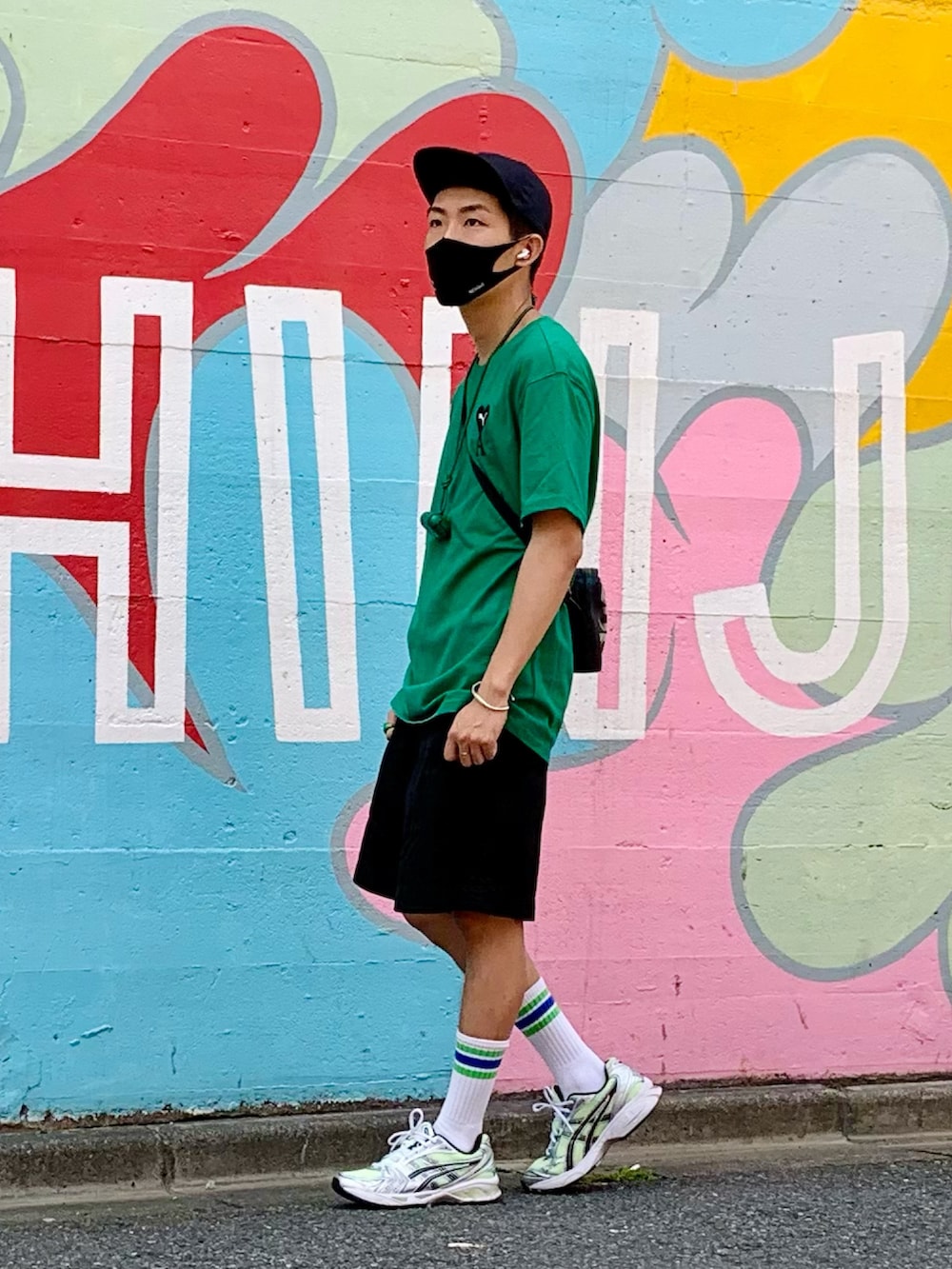 グリーン系のTシャツ/カットソー、ブラック系のパンツ、イエロー系のスニーカーを着用したメンズの夏コーディネートの2枚目の写真