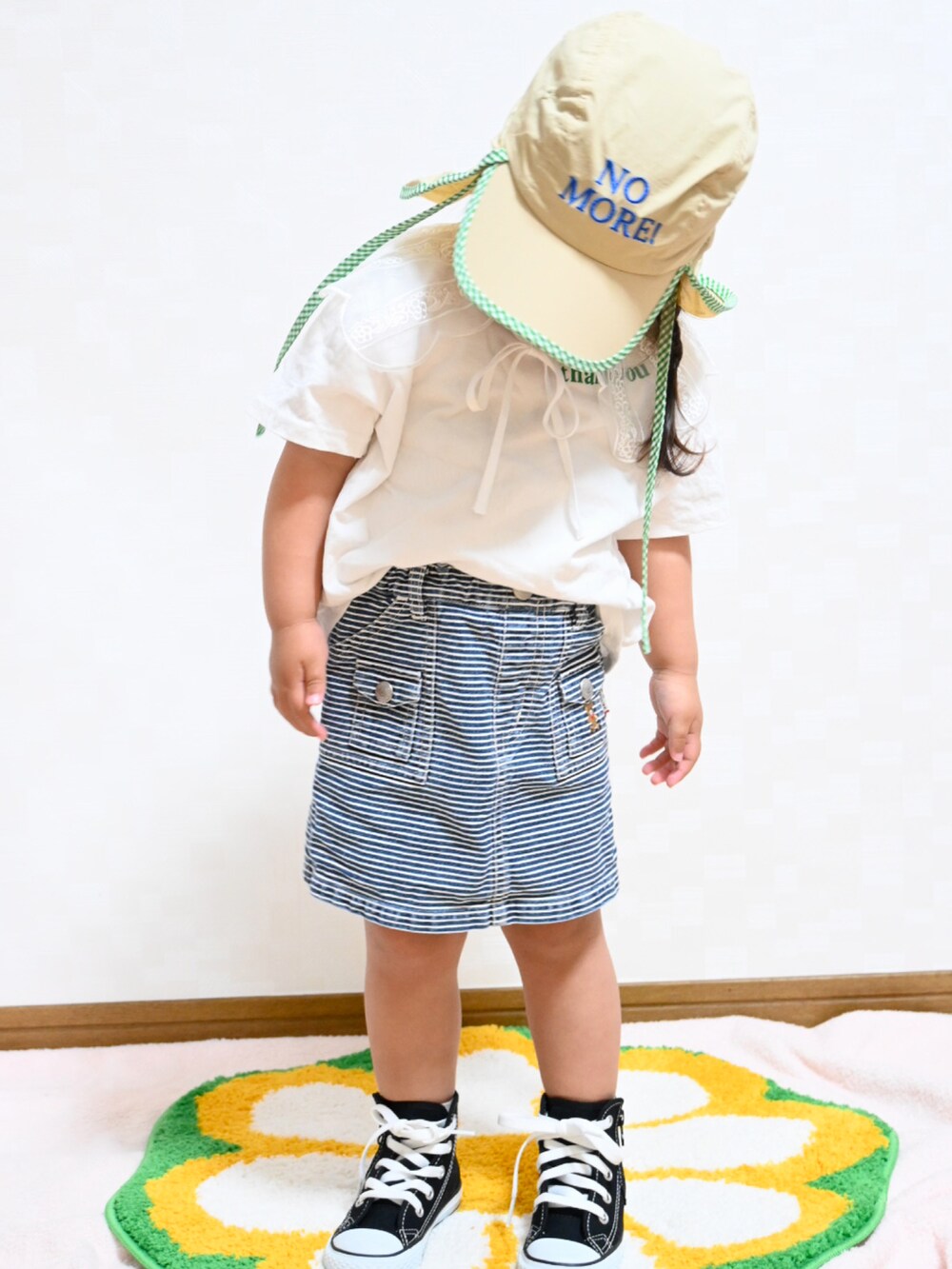 ホワイト系のTシャツ/カットソー、ブルー系のデニムスカート、ブラック系のスニーカーを着用したキッズの春コーディネートの2枚目の写真