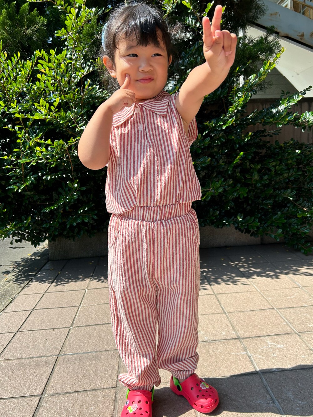 レッド系のパンツ、レッド系のシャツ/ブラウス、レッド系のサンダルを着用したキッズの夏コーディネートの2枚目の写真