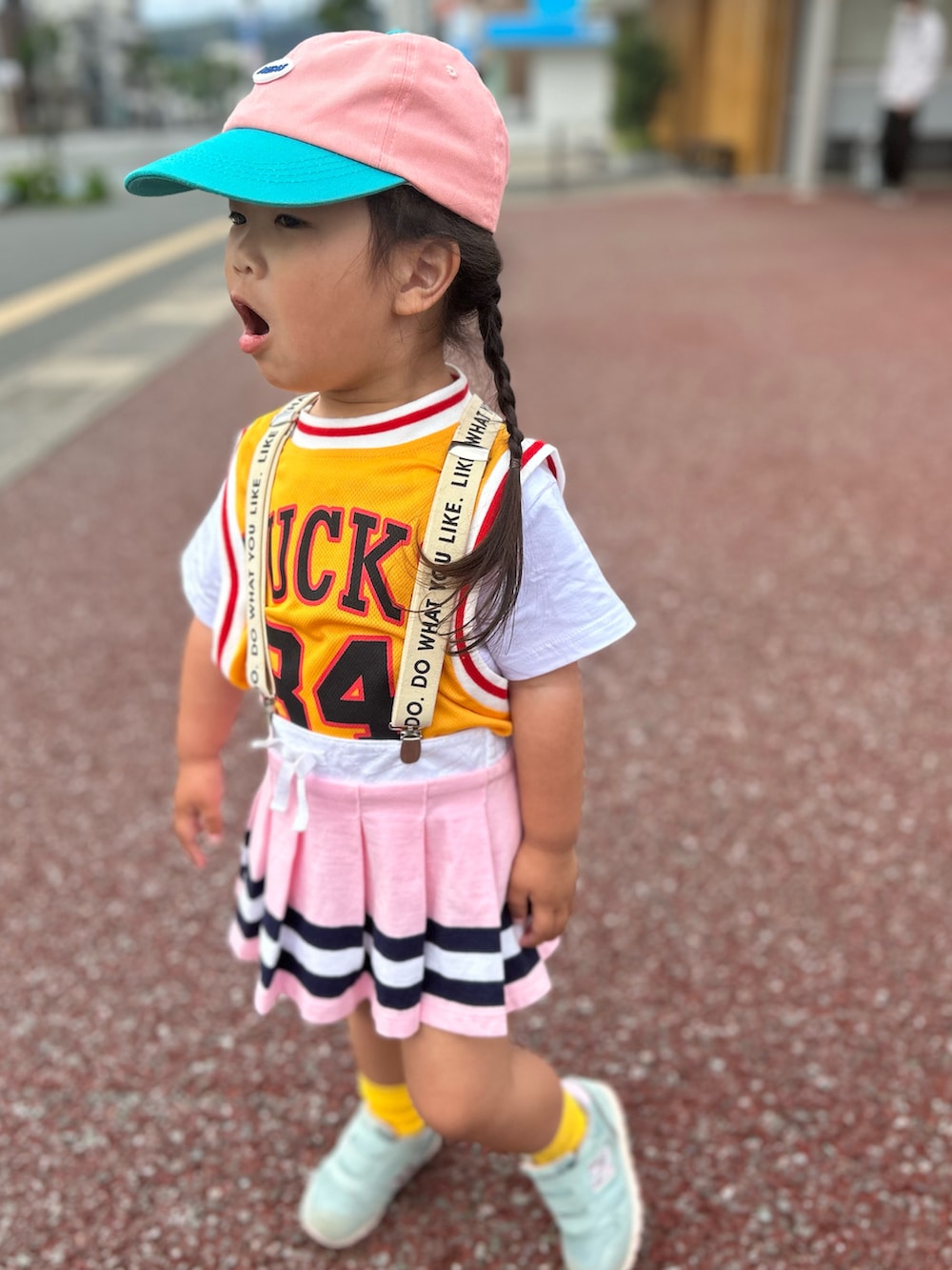 イエロー系のTシャツ/カットソー、ピンク系のスカート、グリーン系のスニーカーを着用したキッズの春コーディネートの3枚目の写真