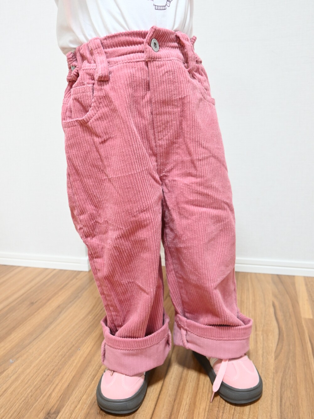 ピンク系のスニーカー、ピンク系のデニムパンツ、オレンジ系のTシャツ/カットソーを着用したキッズの秋コーディネートの2枚目の写真