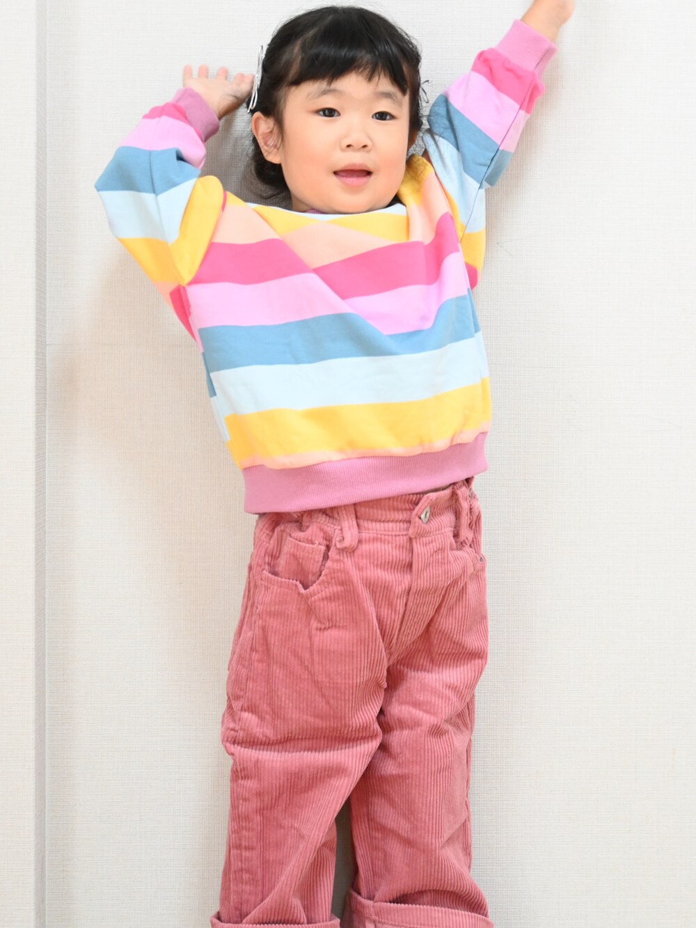 ピンク系のデニムパンツ、ピンク系のスニーカー、その他のスウェットを着用したキッズの秋コーディネートの2枚目の写真