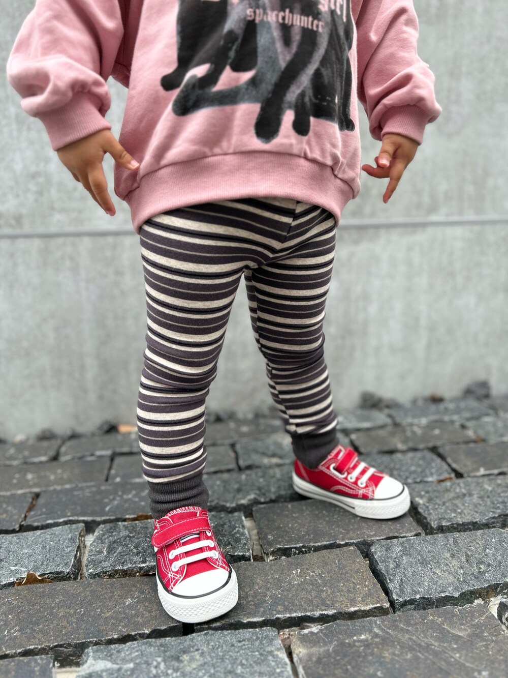 ブラック系のパンツ、ピンク系のスウェットを着用したキッズの春コーディネートの3枚目の写真