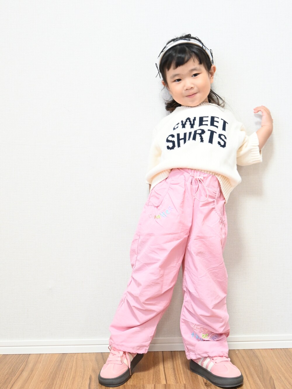 ピンク系のカーゴパンツ、ホワイト系のニット/セーター、ピンク系のスニーカーを着用したキッズの秋コーディネートの2枚目の写真