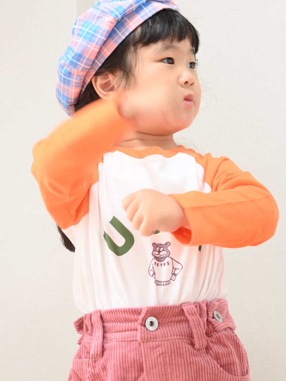 ピンク系のスニーカー、ピンク系のデニムパンツ、オレンジ系のTシャツ/カットソーを着用したキッズの秋コーディネートの3枚目の写真