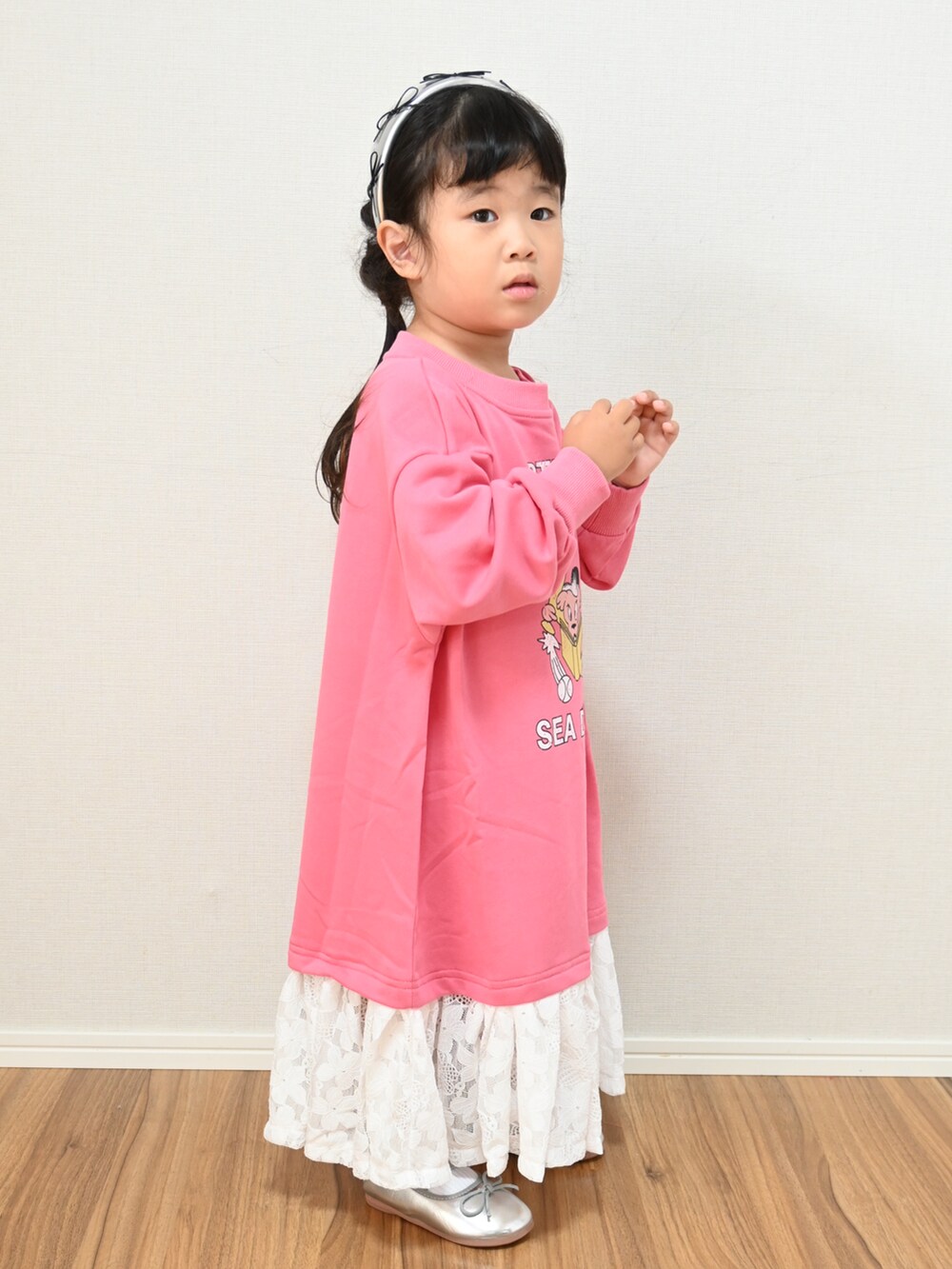 ピンク系のワンピース、シルバー系のバレエシューズ、シルバー系のカチューシャを着用したキッズの秋コーディネートの2枚目の写真