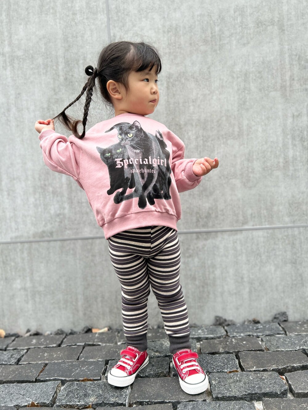 ブラック系のパンツ、ピンク系のスウェットを着用したキッズの春コーディネートの2枚目の写真