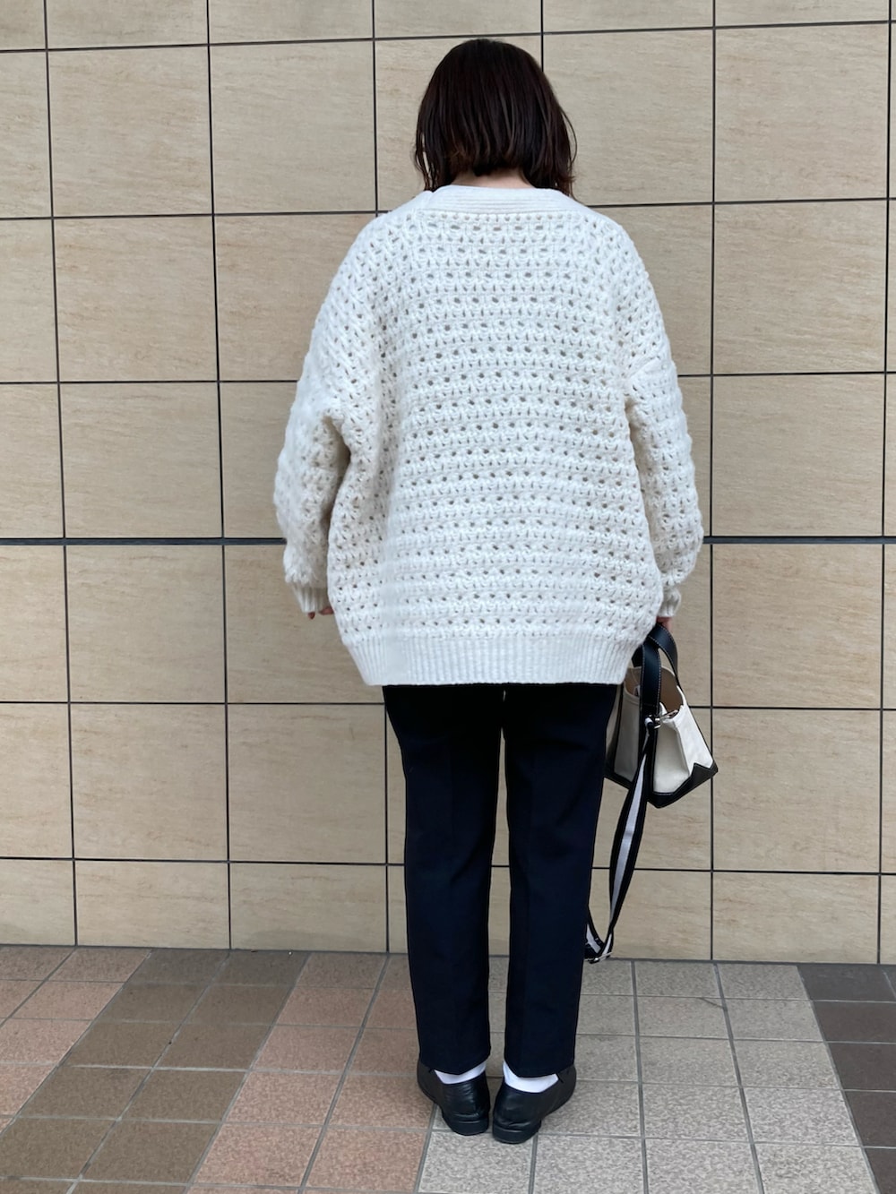 ブラック系のその他パンツ、ホワイト系のカーディガン/ボレロ、ベージュ系のトートバッグを着用したレディースの春コーディネートの3枚目の写真