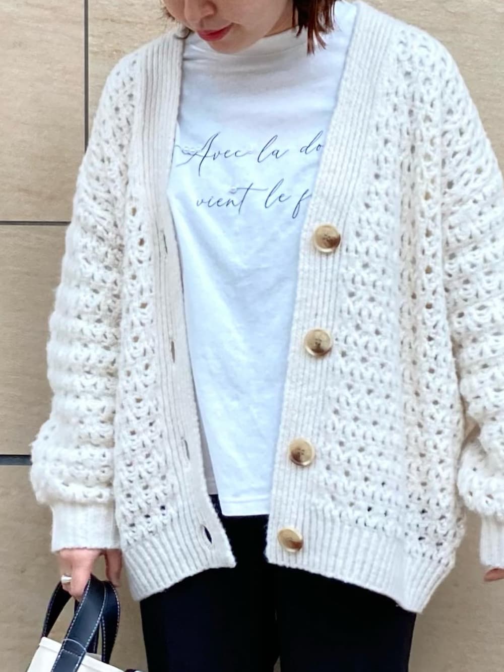 ブラック系のその他パンツ、ホワイト系のカーディガン/ボレロ、ベージュ系のトートバッグを着用したレディースの春コーディネートの2枚目の写真