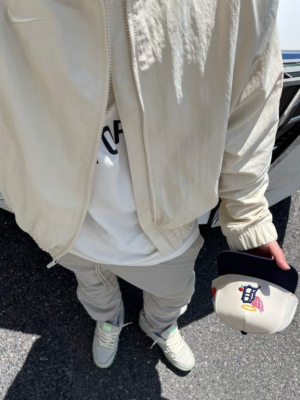 ベージュ系のナイロンジャケットを着用したメンズの春コーディネートの2枚目の写真