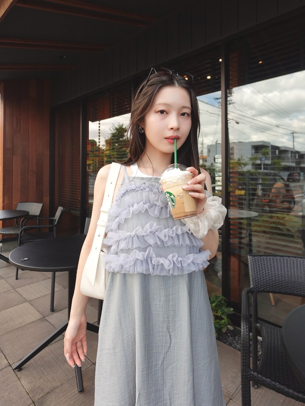 グレー系のワンピース、シルバー系のTシャツ/カットソー、ベージュ系のショルダーバッグを着用したレディースの夏コーディネートの3枚目の写真