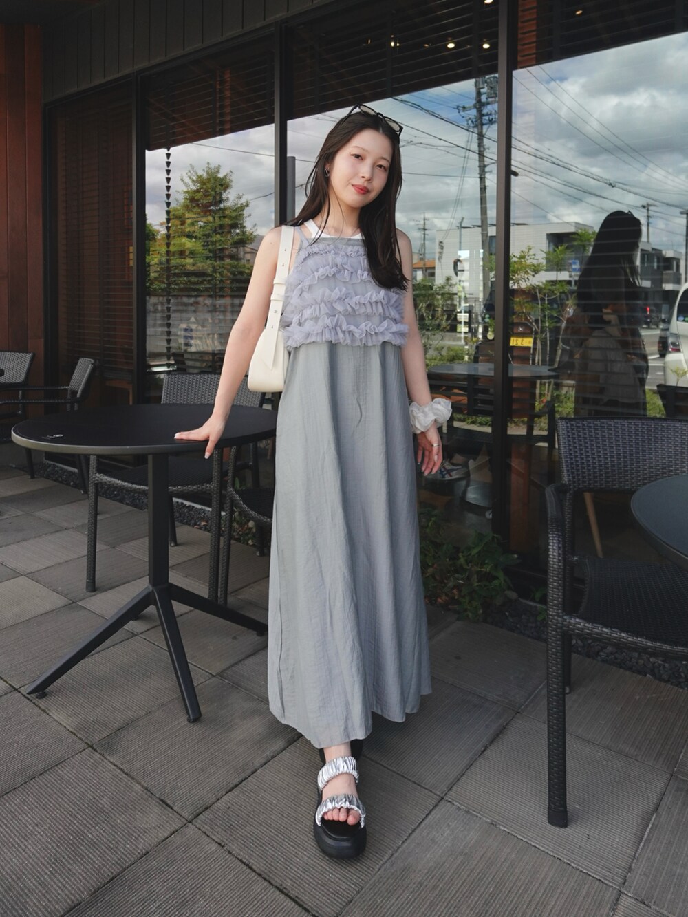 グレー系のワンピース、シルバー系のTシャツ/カットソー、ベージュ系のショルダーバッグを着用したレディースの夏コーディネートの4枚目の写真