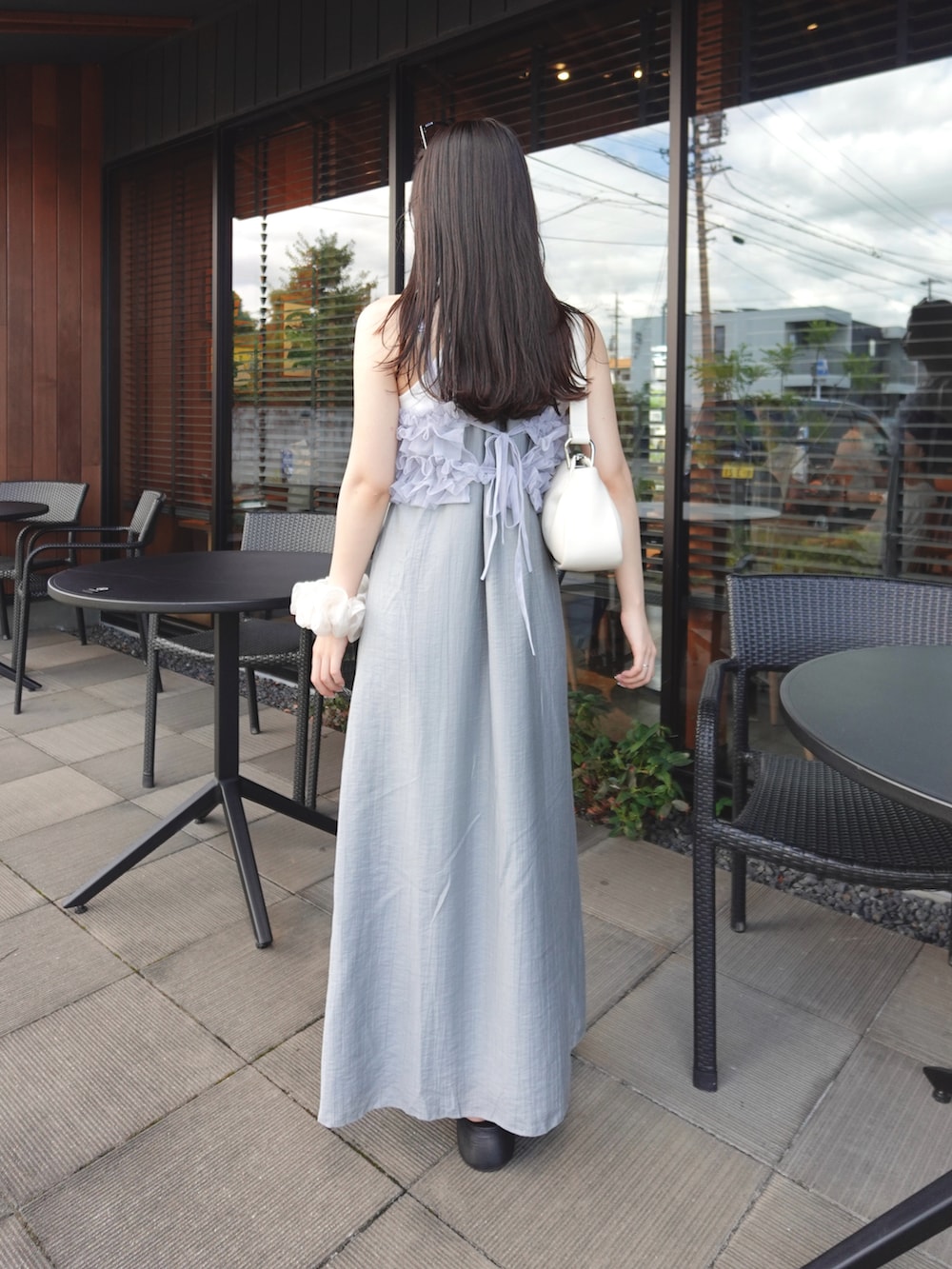 グレー系のワンピース、シルバー系のTシャツ/カットソー、ベージュ系のショルダーバッグを着用したレディースの夏コーディネートの2枚目の写真