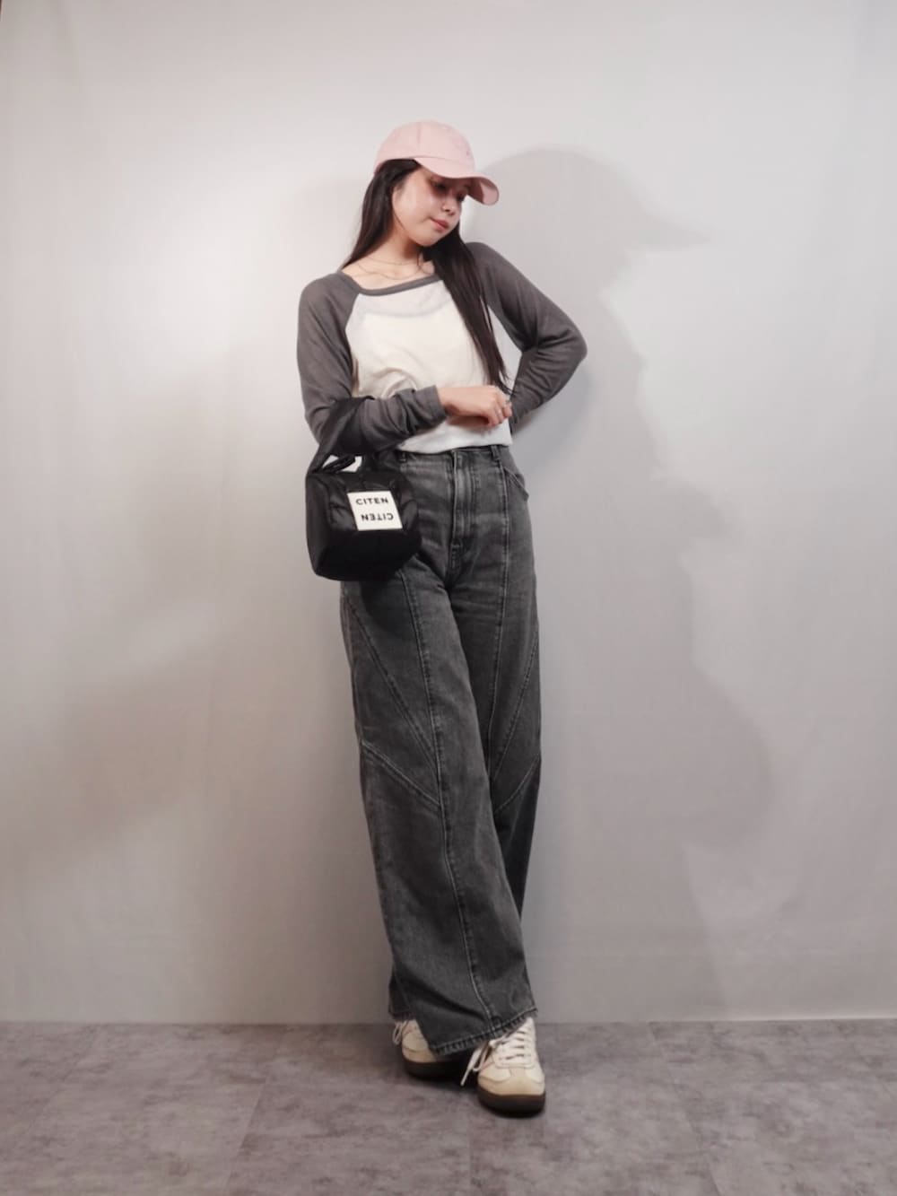 グレー系のデニムパンツ、ホワイト系のスニーカー、ブラック系のハンドバッグを着用したレディースの春コーディネートの3枚目の写真