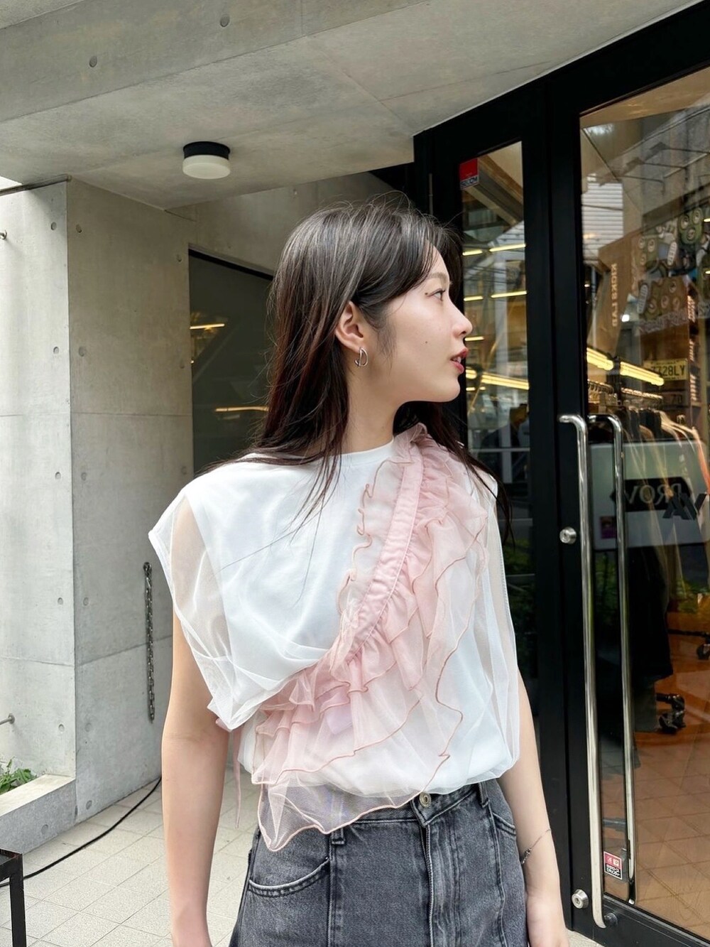 ピンク系のサンダル、ブラック系のデニムパンツ、ブラック系のハンドバッグを着用したレディースの春コーディネートの4枚目の写真