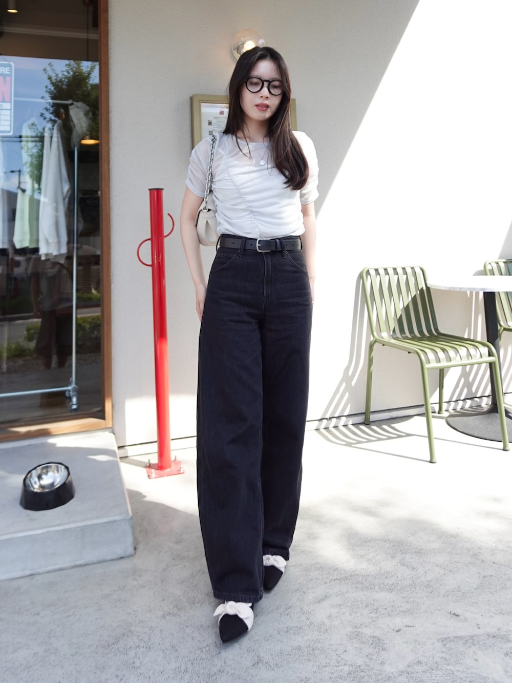 ブラック系のデニムパンツ、シルバー系のTシャツ/カットソー、ベージュ系のショルダーバッグを着用したレディースの夏コーディネートの4枚目の写真