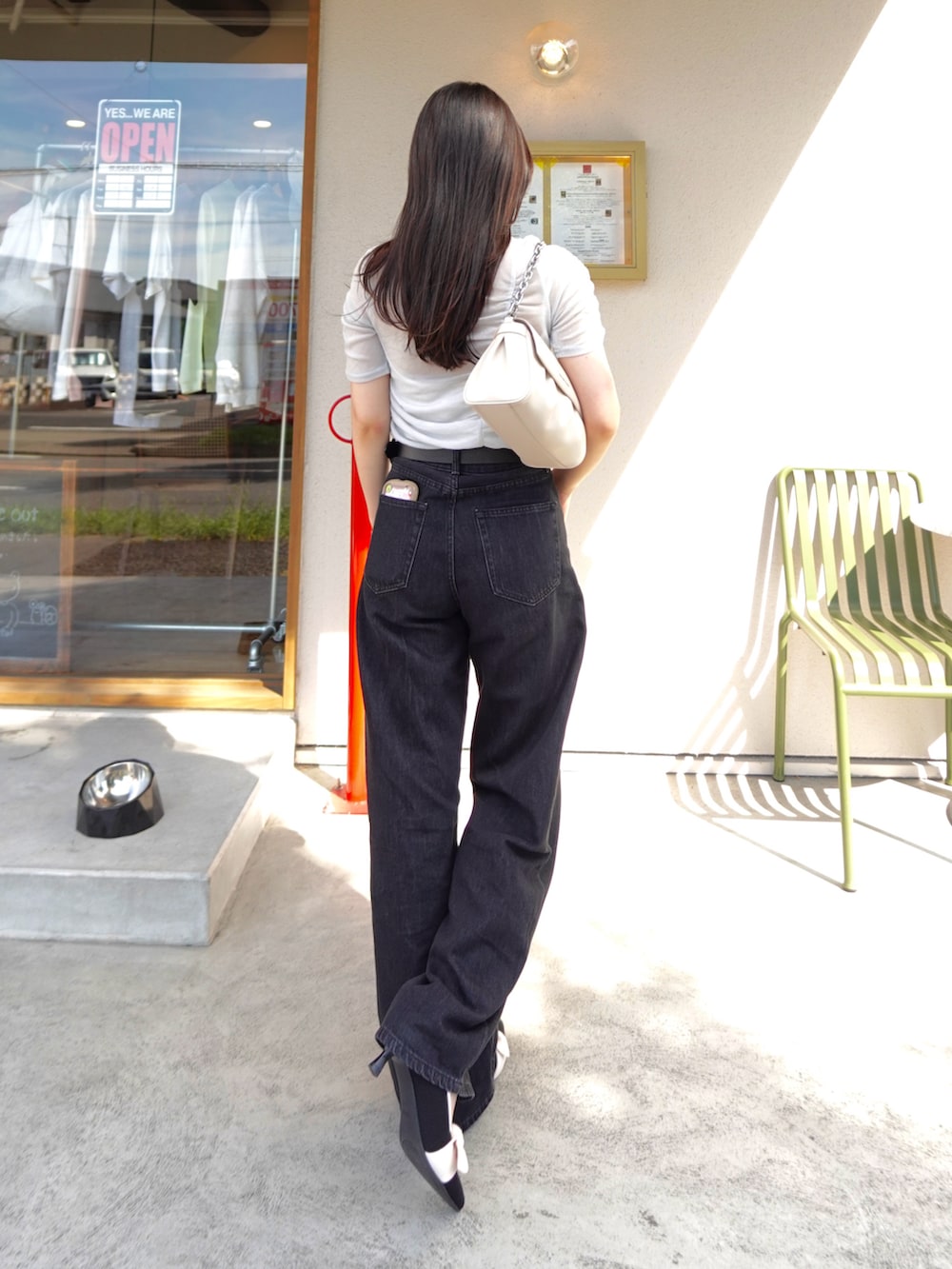 ブラック系のデニムパンツ、シルバー系のTシャツ/カットソー、ベージュ系のショルダーバッグを着用したレディースの夏コーディネートの3枚目の写真