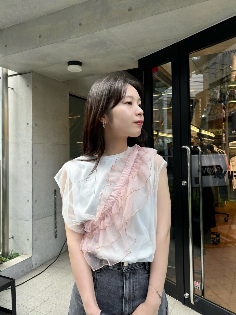 ピンク系のサンダル、ブラック系のデニムパンツ、ブラック系のハンドバッグを着用したレディースの春コーディネートの3枚目の写真