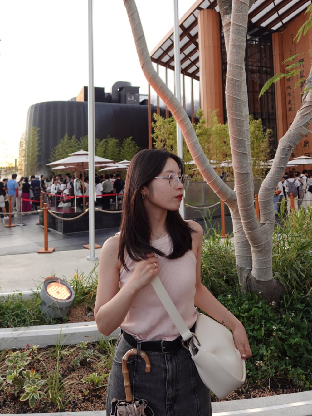 ブラック系のデニムパンツ、ホワイト系のスニーカー、ホワイト系のタンクトップを着用したレディースの秋コーディネートの4枚目の写真