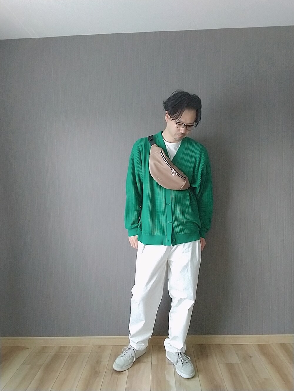 グレー系のスニーカー、ホワイト系のチノパンツ、グレー系のマウンテンパーカーを着用したメンズの春コーディネートの2枚目の写真