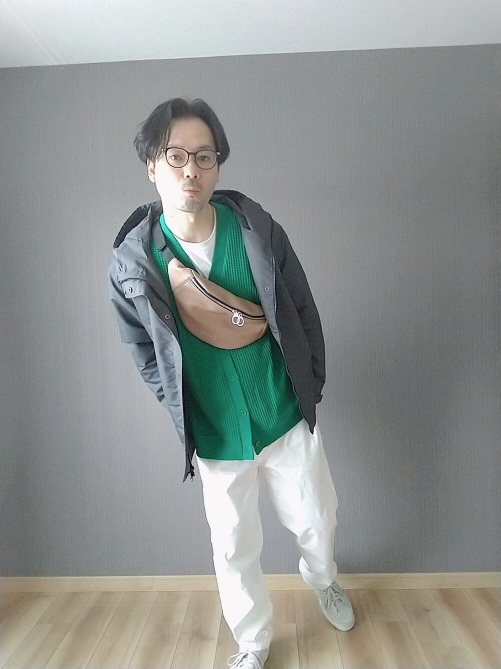 グレー系のスニーカー、ホワイト系のチノパンツ、グレー系のマウンテンパーカーを着用したメンズの春コーディネートの3枚目の写真