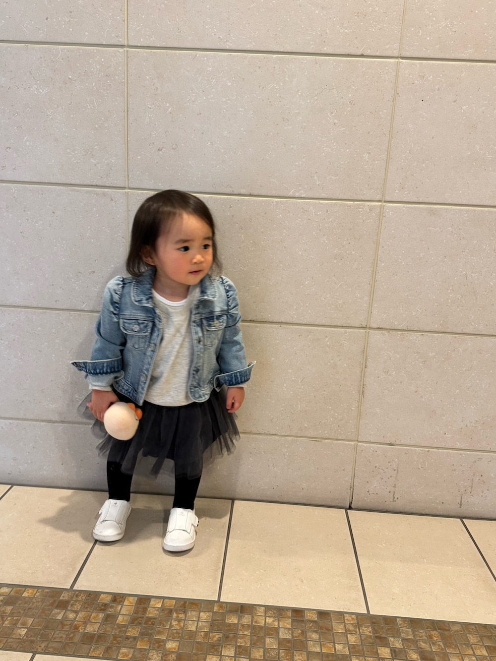 ブルー系のデニムジャケット、グレー系のスカート、グレー系のスウェットを着用したキッズの冬コーディネートの2枚目の写真