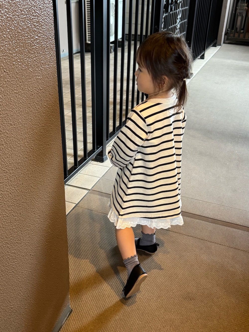 ホワイト系のワンピース、ブラック系のバレエシューズ、グレー系のソックス/靴下を着用したキッズの秋コーディネートの2枚目の写真