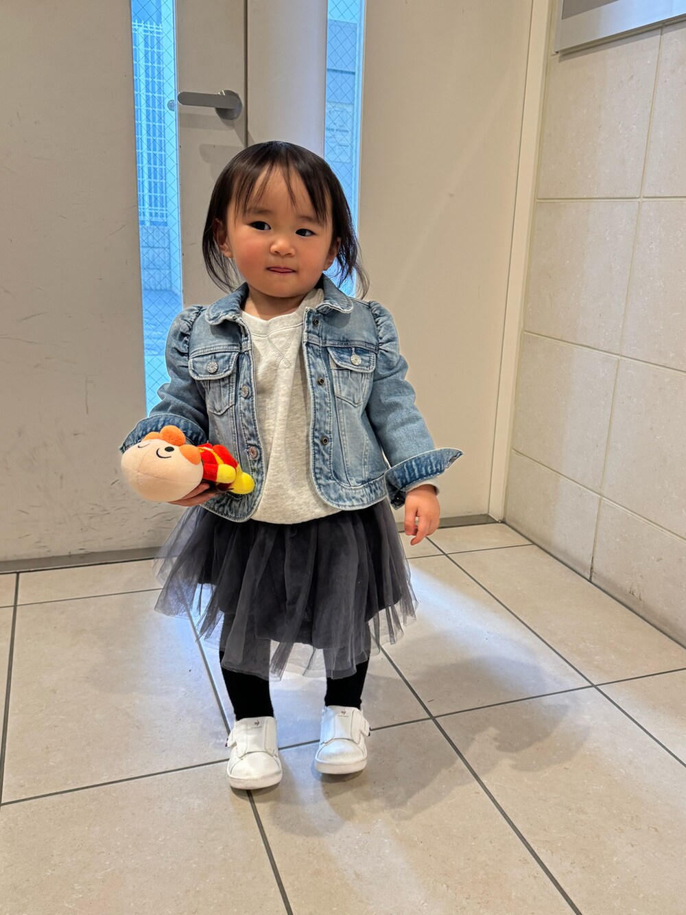 ブルー系のデニムジャケット、グレー系のスカート、グレー系のスウェットを着用したキッズの冬コーディネートの3枚目の写真