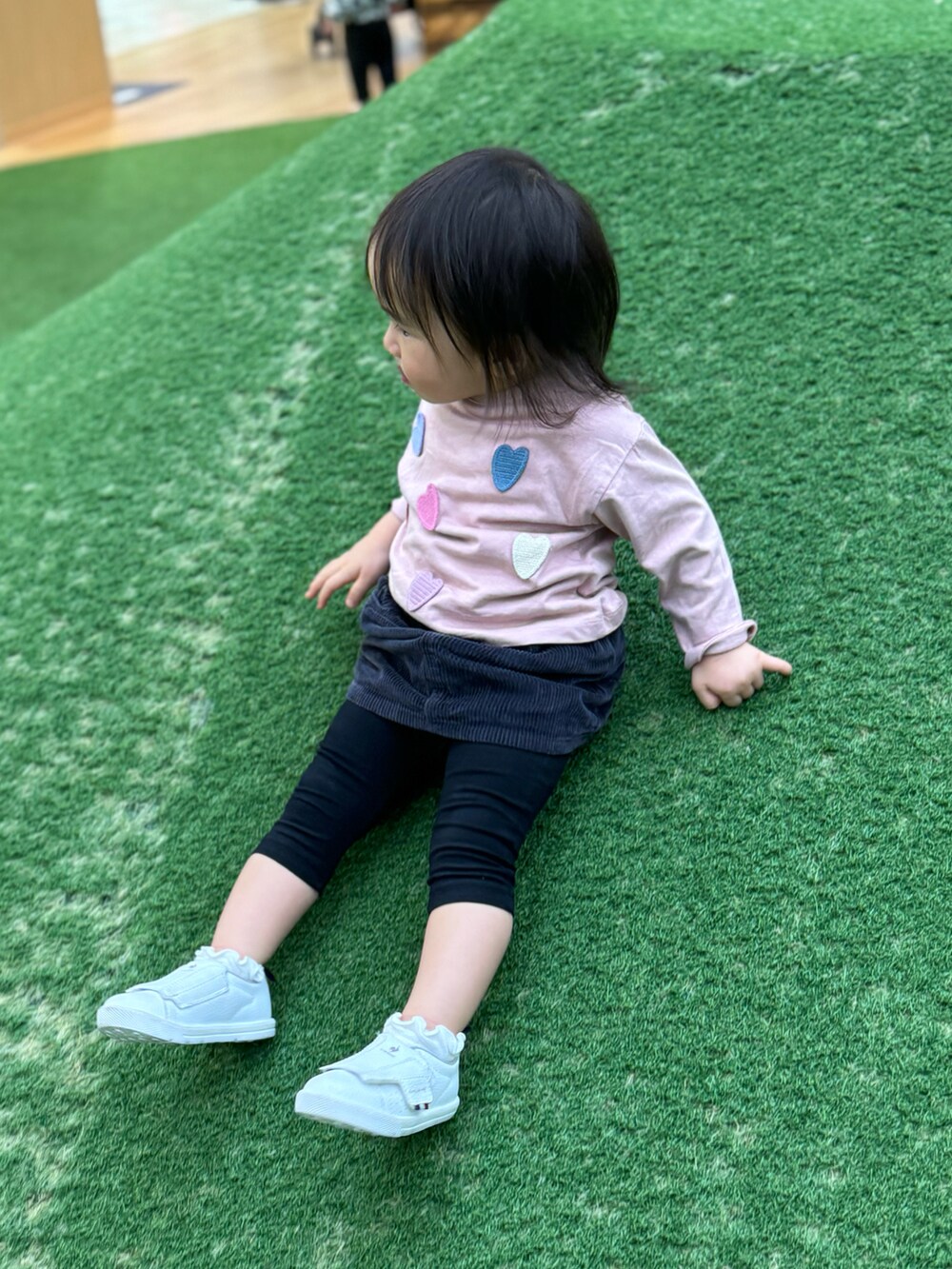 ピンク系のTシャツ/カットソー、グレー系のスカート、ホワイト系のスニーカーを着用したキッズの冬コーディネートの2枚目の写真