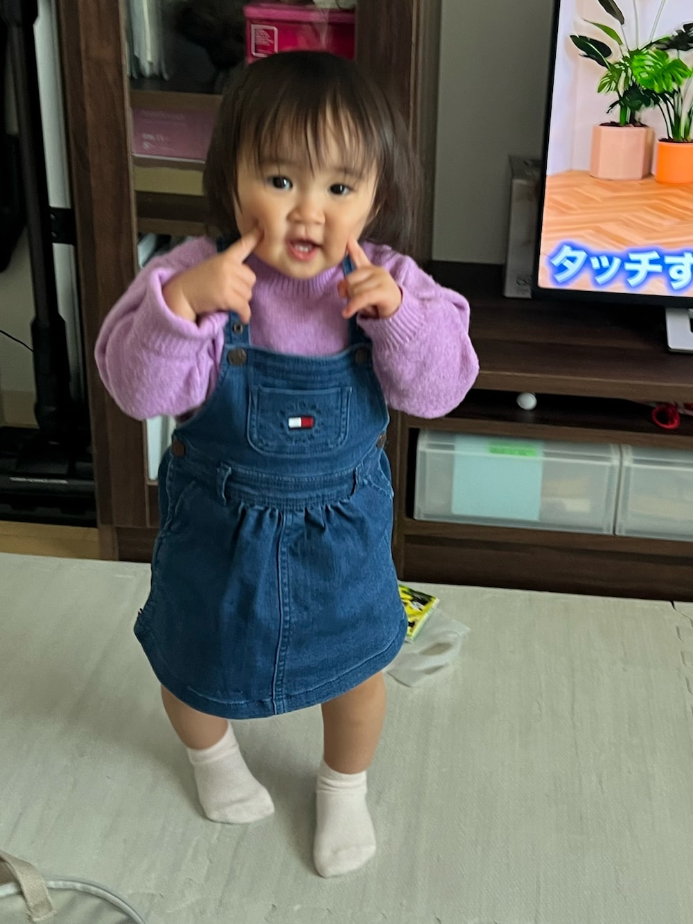 パープル系のニット/セーター、ブルー系のデニムスカート、ベージュ系のレギンス/スパッツを着用したキッズの冬コーディネートの2枚目の写真