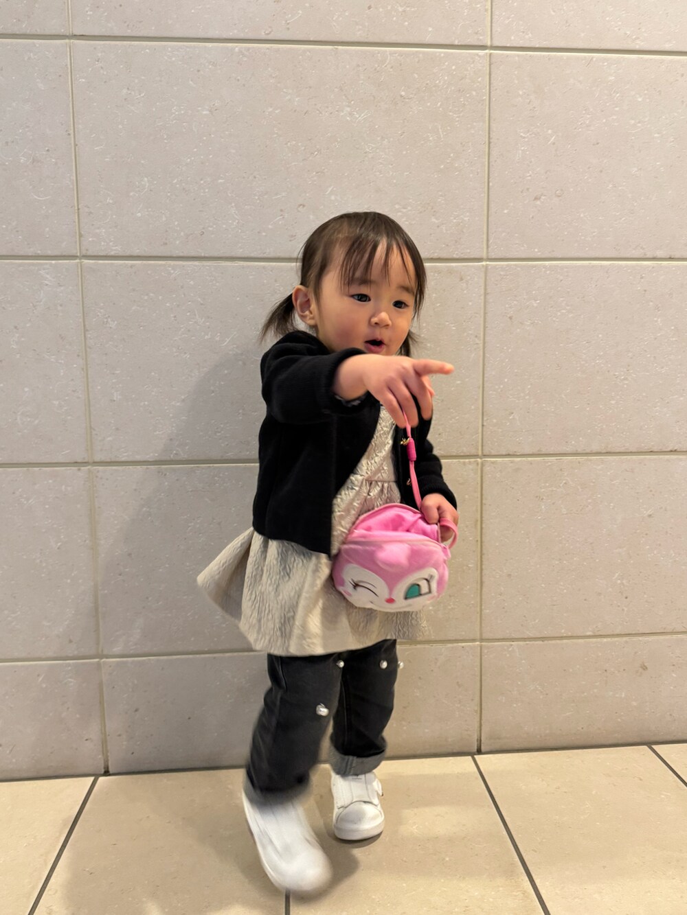 ブラック系のカーディガン/ボレロ、ベージュ系のアンサンブル、ブラック系のその他パンツを着用したキッズの春コーディネートの2枚目の写真